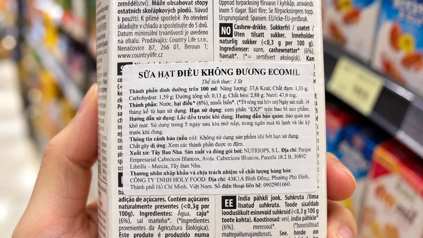 A close-up of a Vietnamese supplementary label, or 'nh&atilde;n phụ', on an imported grocery item highlighting the ingredients